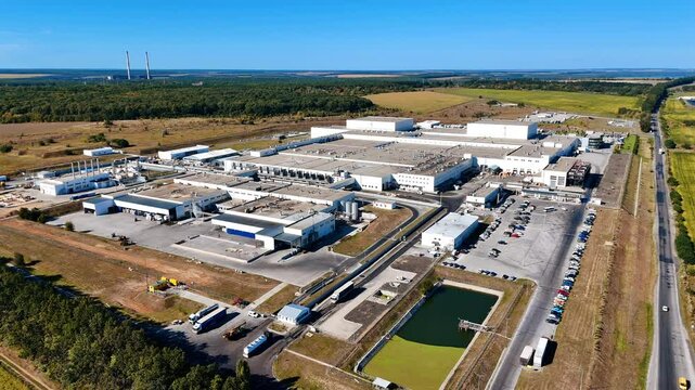 Food factory territory outside a big city. Aerial perspective on the premises of industrial plant in the surrounding of nature.