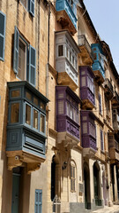 Typical narrow streets with colorful balconies in Malta. Traditional colorful balconies in old town of Valletta, Malta. Architecture background. Facade of the building in the old town, Malta island