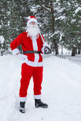 Santa Claus cleans snow with shovel in winter outdoors after a snowfall. Cleaning the streets in the village, clearing the passage for cars, difficult weather conditions for Christmas and New Year