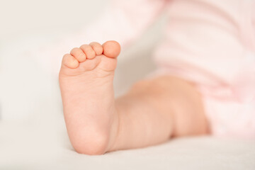 a baby's foot on a white background, a small pink heel of a baby