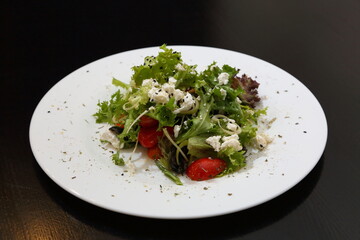 Salad with feta cheese. Salad with cheese, tomatoes and herbs.
