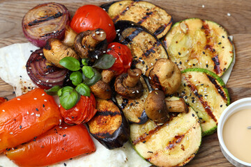 Grilled vegetables with sauce. Baked tomatoes, mushrooms, zucchini, sweet peppers and onions. Grilled vegetables are simply delicious.