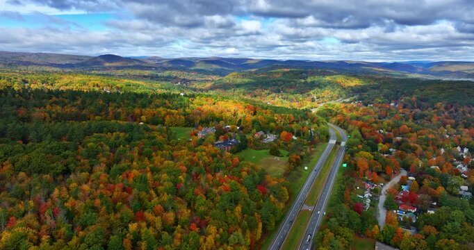 Two parallel highways crossing the vast wooded landscape. Colorful nature of Vermont, New England, USA in autumn. Aerial view.