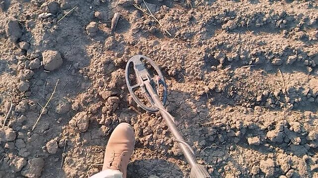 A professional sapper searches for a minefield using a metal detector.