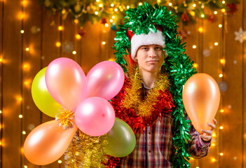 A teenage boy poses in New Year decorations with festive illumination and garlands, Christmas lights and decorations, Holiday theme