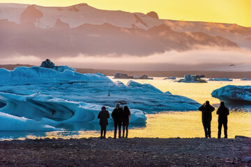 Ice Lagoon. Silhouette of tourists taking photo of sunset Ice lagoon. South Iceland, Jokulsarlon Ice Waterfall. Great tourist attraction.