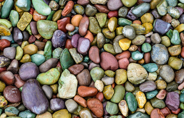 Multicolored rounded stones in the interior of a flowerbed near a recreation area, USA