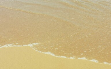 Tide mark on yellow sandy beach with space for copy