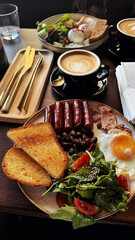 Full English breakfast on a plate with fried eggs, sausages, bacon, beans, toasts and coffee on wooden table in the restaurant. Vertical image. Lifestyle photo. Delicious breakfast or lunch. Food.