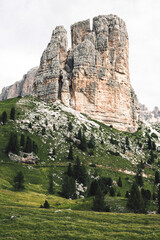 A prominent and large rock formation located in a grassy field area
