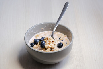 Bright and appetizing breakfast: fresh yogurt with juicy blueberries, crunchy flakes, seeds, and natural grains.