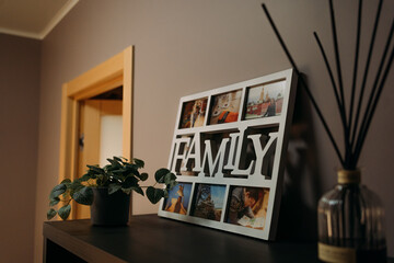 Family-themed photo frame on a shelf, showcasing cherished memories with a potted plant nearby, creating a warm and cozy home atmosphere