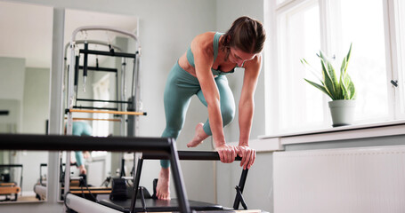 Fototapeta premium Woman Doing Pilates Workout In Gym