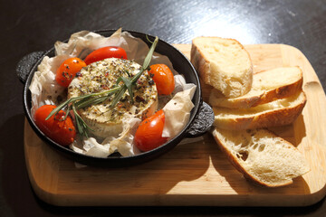 Grilled Camembert. Grilled Camembert cheese with tomatoes and bread.
