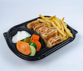 Close up of chicken shawarma meal with lettuce, tomato and onion on white background.
