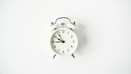 Small vintage-style alarm clock on a clean, empty surface, creating a serene and simple composition. 