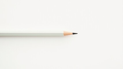 Close-up of a sharpened pencil with a light gray body on a white background, ideal for writing or drawing. Everyday things for creativity and work.
