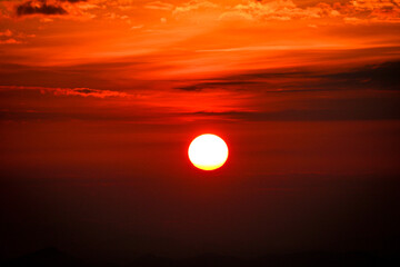 deep red sunset over the mountains with grey mist