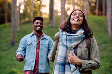 Fototapeta premium Carefree woman walking with her boyfriend in nature during autumn.