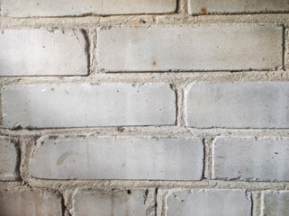 Close-up view of a textured brick wall, showcasing the rough surface and natural imperfections. Ideal for backgrounds, rustic designs, or architectural themes.
