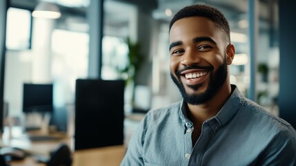 Naklejka premium A smiling man with a beard is sitting at a desk in an office