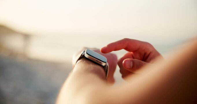 Person, hands and smart watch with app on beach for fitness tracker or step counter in nature. Closeup, runner or user with wristwatch for checking calories, distance or performance on ocean coast