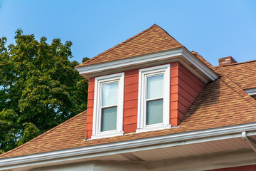 Hip dormer window on the sloped roof of a family house in Brighton, Massachusetts, USA