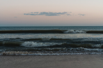 Smooth, blurred waves reflecting dusk light in serene tones.