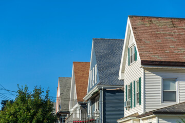 Row of traditional gable-roof houses on sunny summer day in Brighton, Massachusetts, USA