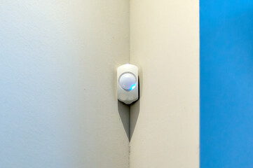 Alarm system presence detector on a wall with space for text with white background and blue right side