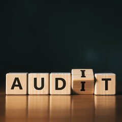 Wooden blocks spelling AUDIT, concept of financial review, analysis, and assessment for business...