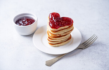 Pancakes with strawberry jam in the form of heart for Valentine's day holiday