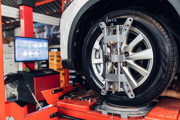 Fototapeta premium Car wheel centering machine adjustment. Auto service mechanic installing wheel alignment sensor on tire during vehicle suspension alignment adjustment