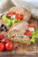 Sliced sandwich with grilled minced meat closeup on wooden cutting board. Kofta sandwich