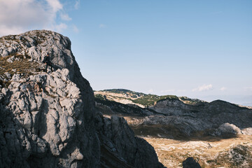 Beautiful mountain landscape with people hiking under the sun 