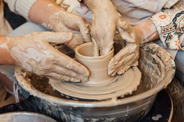 Cropped shot of unrecognizable child making ceramic mug at pottery class