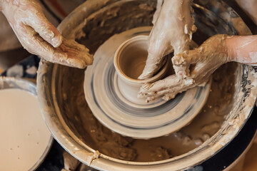Cropped shot of unrecognizable child making ceramic mug at pottery class