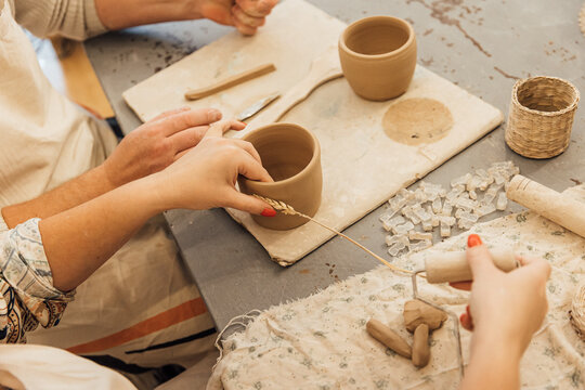 Cropped shot of unrecognizable child making ceramic mug at pottery class