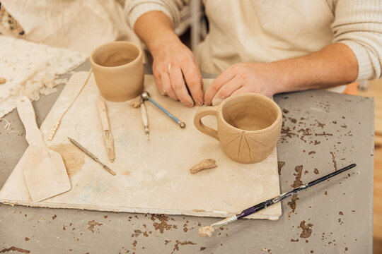 Cropped shot of unrecognizable child making ceramic mug at pottery class