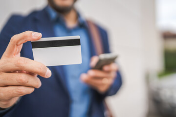 close up of unknown man hold mobile phone and credit card
