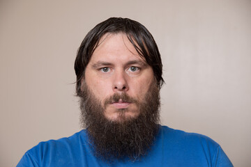 Obraz premium Portrait of a Bearded Man in a Blue Shirt