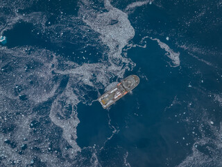 Aerial top view of a ship in Antarctic waters with drifting ice © Aaron