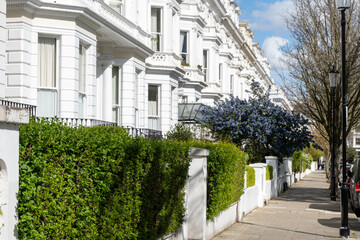 Notting Hill, walking on streets with white houses and flowering gardens in spring, city life, wealthy neighbourhoods in London, UK
