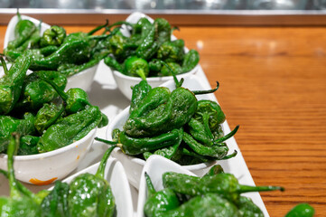 Typical snacks of Basque Country, pinchos or pinxtos skewers with small pieces of bread, fish, sea food, sweet green pepper served in bar in San-Sebastian or Bilbao, Spain