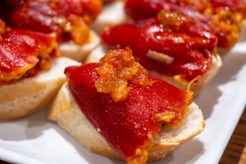 Typical snacks of Basque Country, pinchos or pinxtos skewers with small pieces of bread, fish, sea food, sweet green pepper served in bar in San-Sebastian or Bilbao, Spain