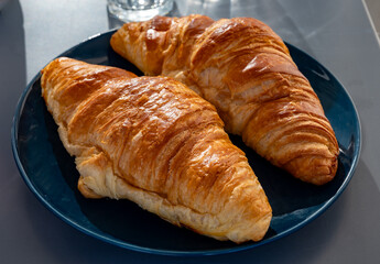 Fresh baked buttered croissants served in restaurant for continental or French breakfast close up