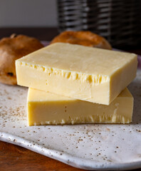 Block of aged cheddar cheese, the most popular type of cheese in United Kingdom and USA, natural cheese from cow milk