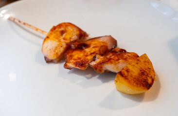 Typical snacks of Basque Country, pinchos or pinxtos skewers with small pieces of bread, fish, sea food, sweet green pepper served in bar in San-Sebastian or Bilbao, Spain