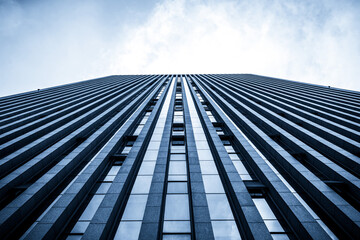 Dramatic Low Angle View of Skyscraper Against Cloudy Sky
