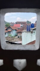 A window with a black frame and a white background. The window is open and the view is of a city